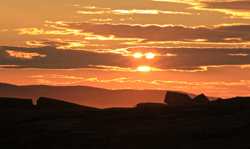 Thanks to some clouds, the setting sun takes on eyes and a mouth